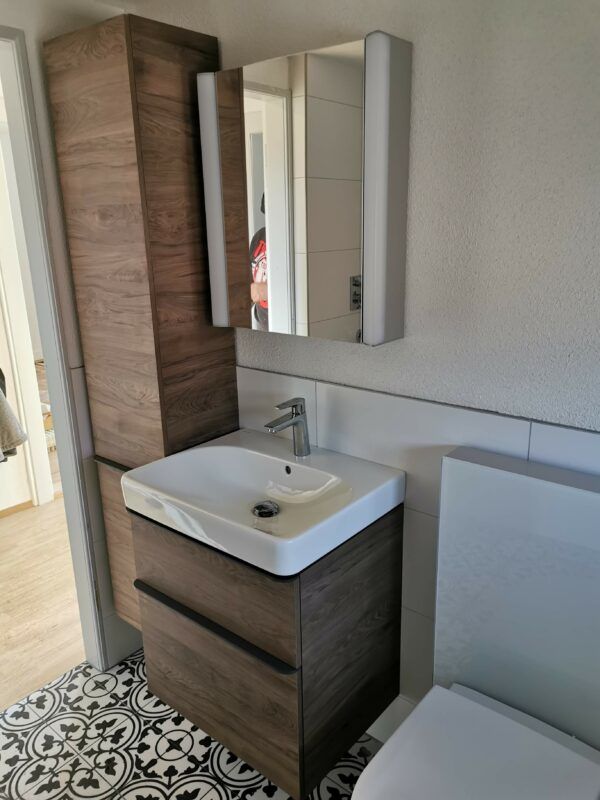 Waschtisch mit Hochschrank, Spiegelschrank und gemusterten Bodenplatten